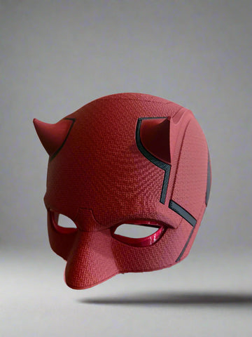 Red mask with black accents on a reflective surface