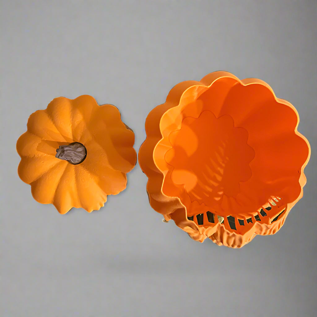 Two orange plastic molds shaped like pumpkins