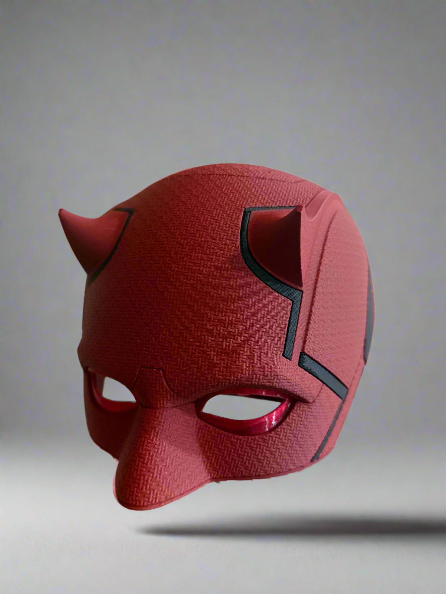Red mask with black accents on a reflective surface