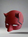 Red mask with black accents on a reflective surface