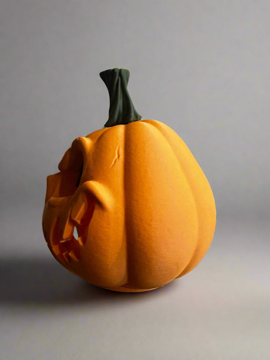 Carved pumpkin on a decorative stand with a gray background