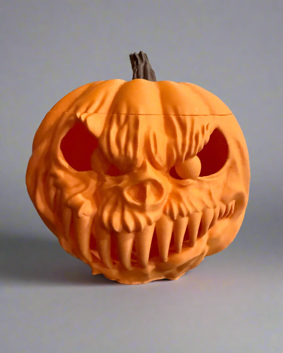 Pumpkin-shaped container with a skull design on a reflective surface