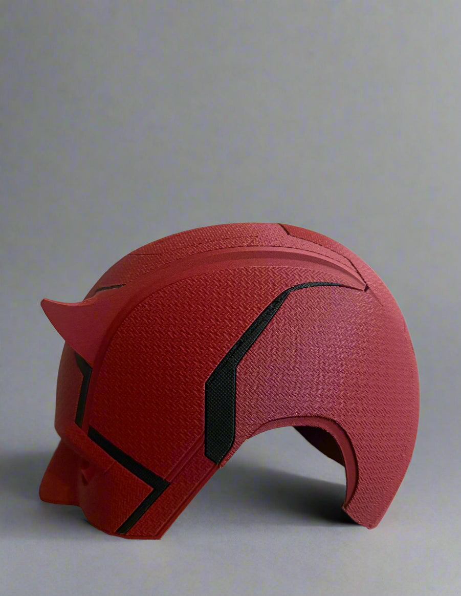 Red mask with black accents on a reflective surface